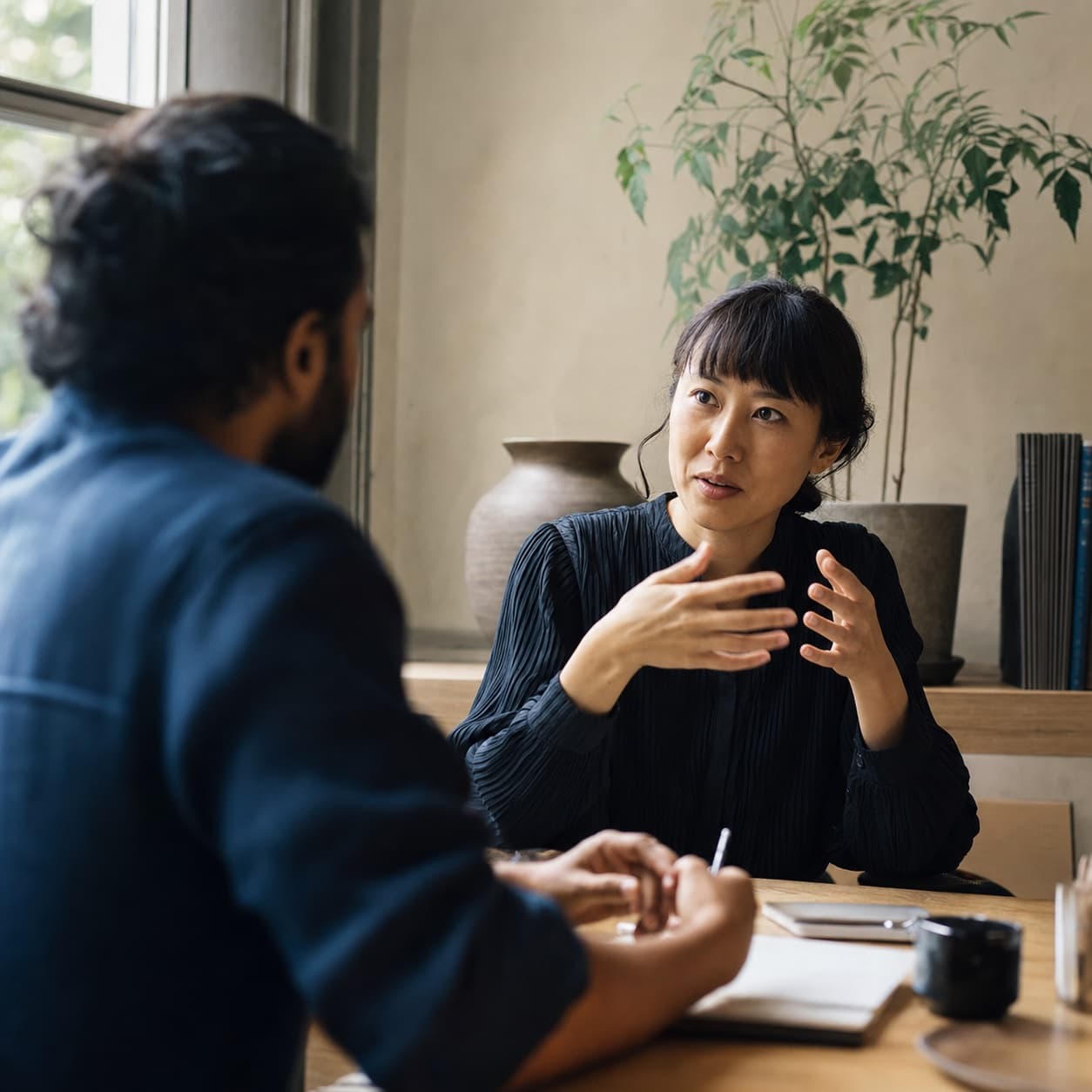 Duas pessoas conversando com atenção em um ambiente de trabalho.